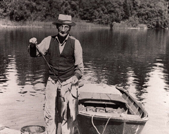 Frank Mullen shows his fishing catch while on the dock at Pattison Lake, 1943