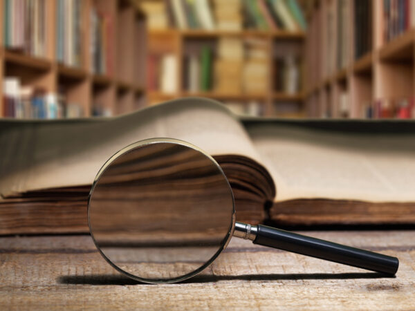 magnifying glass in front of an old book at a library